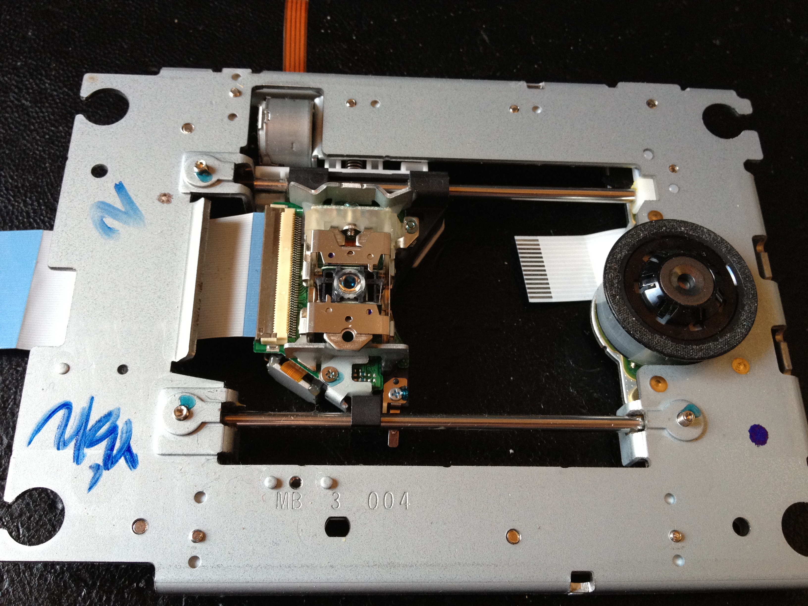 The laser sled assembly removed from the burner, showing the rails, spindle motor and optical unit